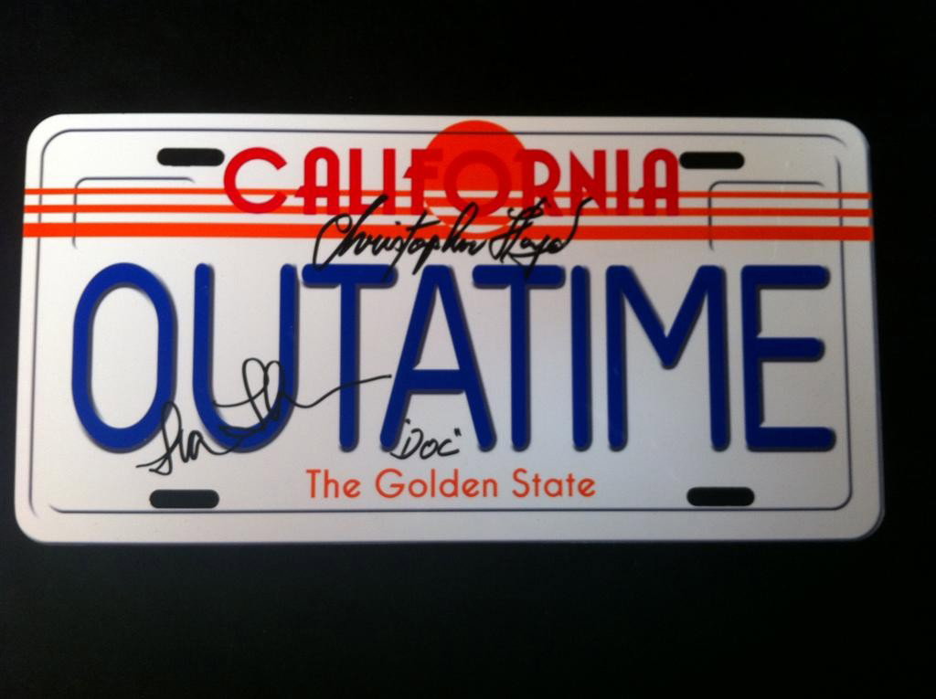 Back to the Future (1985) Autographed License Plat: Back to the Future (1985) - Replica metal "OUTATIME" license plate autographed by Christopher Lloyd and Lea Thompson. Also includes photos of them at signing. 6" x 12"