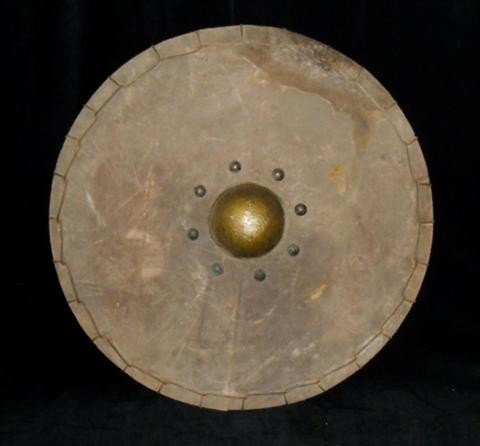 The Mummy Returns (2001) Prop shield: The Mummy Returns (2001) - A screen used prop shield made for the production. Made of wood and covered in leather, the shield has a strap and two handles. Used in the battle scenes. Includes paperwork