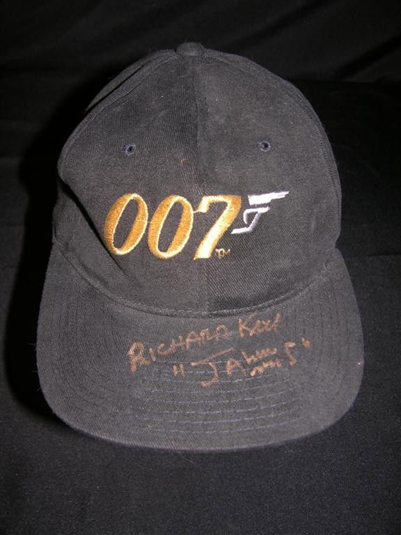 The Spy Who Loved Me Autographed Baseball Cap: Black baseball cap with the 007 logo emblazoned in gold, signed on the brim in gold ink by Richard Kiel, who portrayed Jaws, the steel-tooted henchman of Karl Stromberg, in The Spy Who Loved Me.