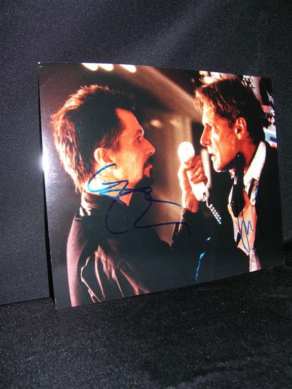 Air Force One Autographed Photo: 8 x 10 color photo from the film Air Force One (1997), signed by the film's stars Harrison Ford and Gary Oldman. The photo depicts a tense scene with Oldman holding a gun to Ford's head. Both actors h