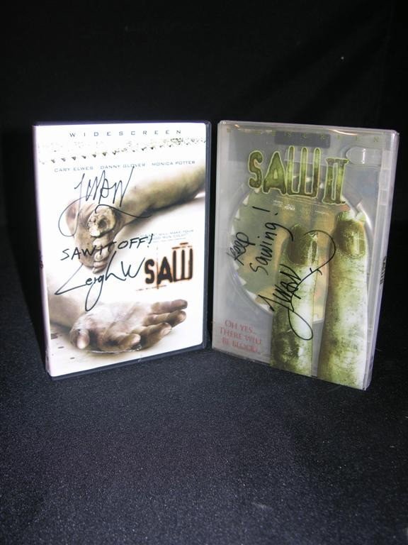 Saw (2004) Autographed DVD: Saw (2004) DVD from Lions Gate, signed in black felt pen by director James Wan and writer Leigh Whannell on the cover. Whannell adds "Saw it off!" This lot further includes a DVD copy of Saw II (2005)