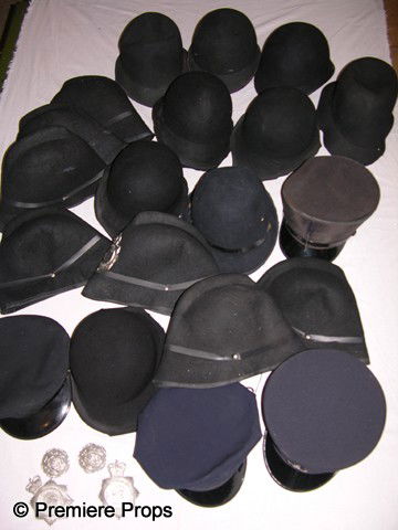 Lot of Conductor Caps: Mixed lot of 21 conductor caps and British Bobby type hats of black and dark blue, with and without badges.