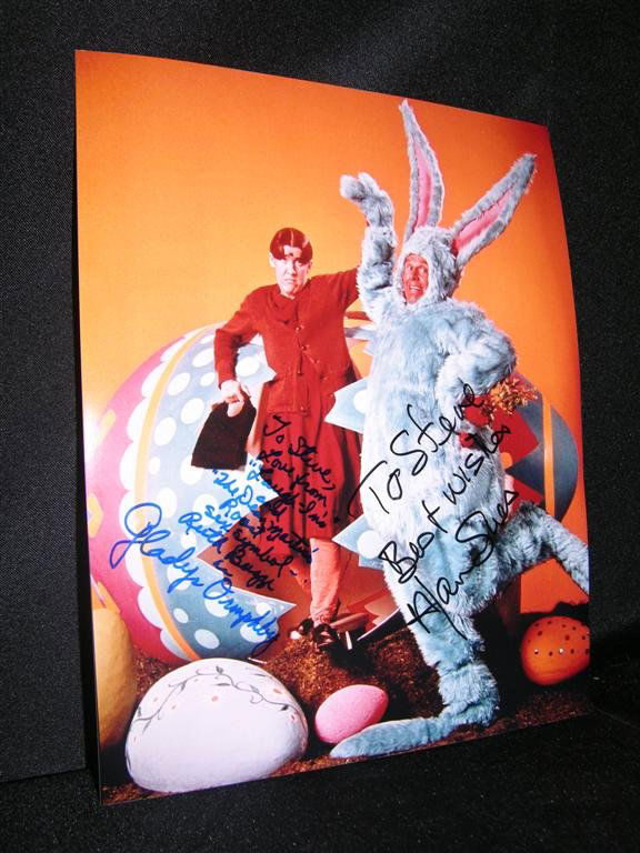 Laugh-In Signed Photo: 8 x 10 color photo of Ruth Buzzi and Alan Sues, both of television's classic Laugh-In, in a comedic pose. Buzzi and Sues have both autographed the photo, with Buzzi personally inscribing "Love from La