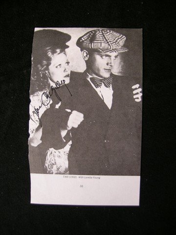 James Cagney Signed Taxi Clipping: From iconic actor James Cagney. This is a B&W autographed promotional clipping from one of his early films, 'Taxi!' The photo depicts Cagney and co-star Loretta Young in a scene from the film and is s
