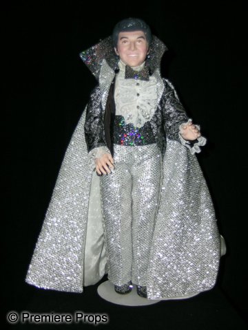 Liberace Effanbee Figurine: This is a marvelous figurine of Liberace in a sparkling black and silver caped tuxedo outfit. The figure is made from molded plastic and the clothes are intricately fashioned down to the tiniest detai