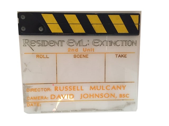 Resident Evil: Extinction Clapboard: Resident Evil: Extinction original, 2nd unit, set used clap board with Director: Russell Mulcany, Camera operator: David Johnson, BSC, engraved. Direct from the producer's office archives. (11"x10")