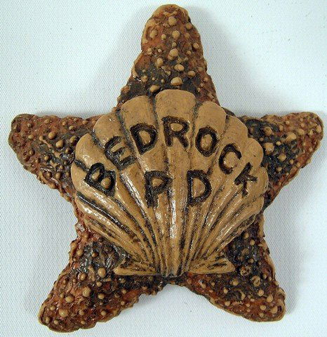 The Flintstones (Feature) Bedrock PD Badge Prop: The beloved Flintstones received a life action feature treatment in 1994 with "The Flintstones", featuring John Goodman, Rick Moranis, Rosie O'Donnell and Halle Berry. This is a prop badge custom made