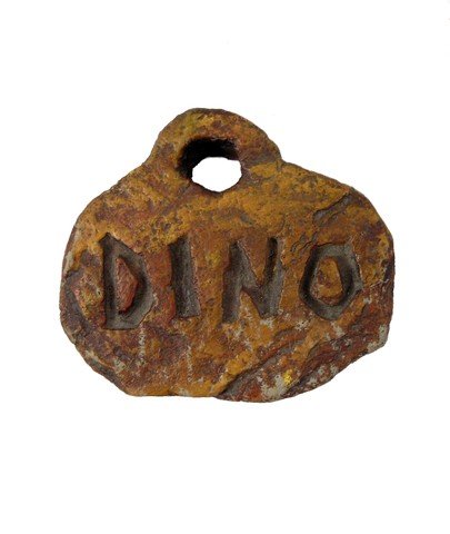 The Flintstones Dino Tag Movie Props: From the hit family favorite feature film, The Flintstones (1994) is Dino's screen used brown rubber 'Dino' dog tag. This comes directly from a team of the production and measures approximately 5" x 4