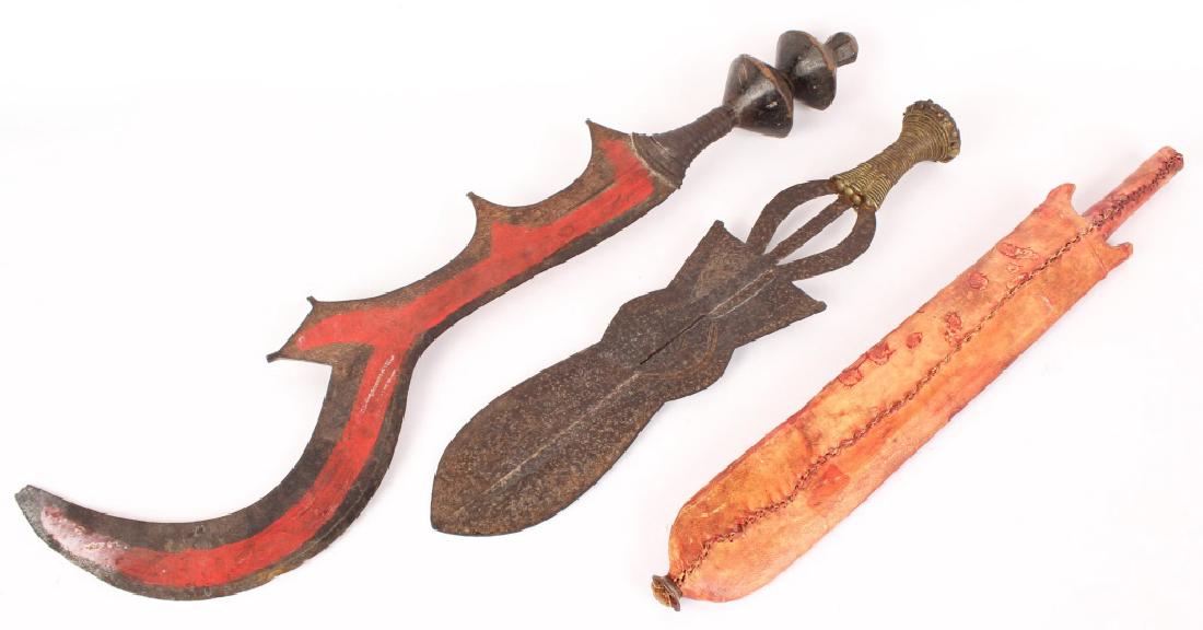 3 METAL AFRICAN EDGED WEAPONS SWORDS MACHETE: 3 METAL AFRICAN EDGED WEAPONS SWORDS MACHETE Lot of 3 African tribal hand swords and 1 machete. Machete in red hide sheath and wooden handle, short hand sword with bronze handle and tool work to blade