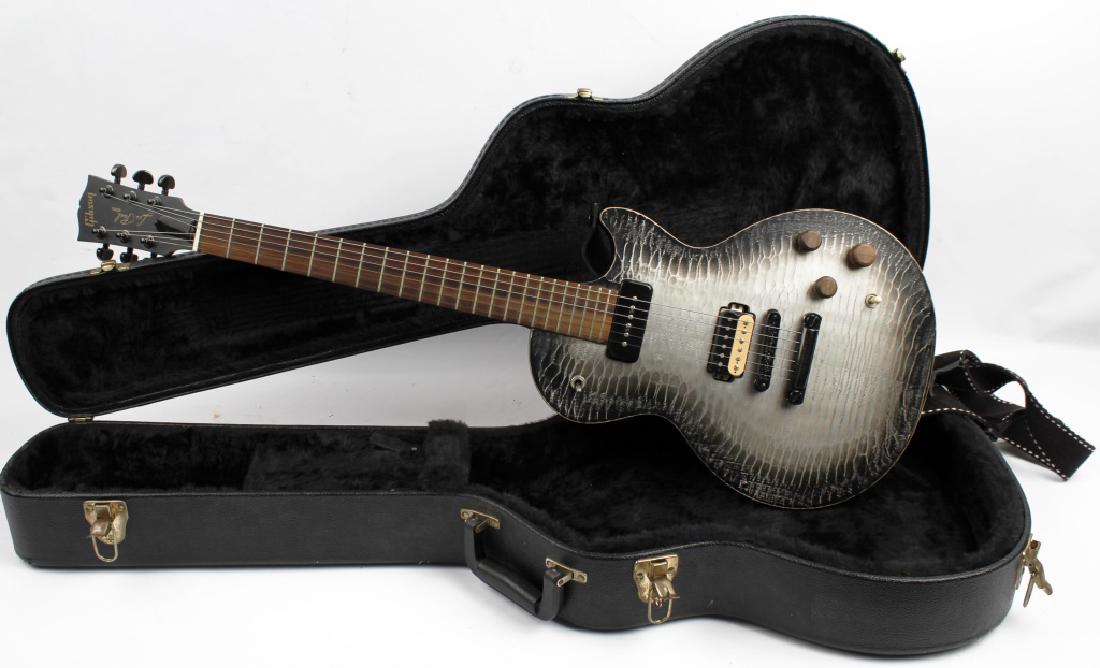 GIBSON LES PAUL MODEL ELECTRIC GUITAR: GIBSON LES PAUL MODEL ELECTRIC GUITAR Gibson Les Paul electric guitar, custom design, with a silver and black alligator finish, custom wooden details. Black leather case with black fur lining.