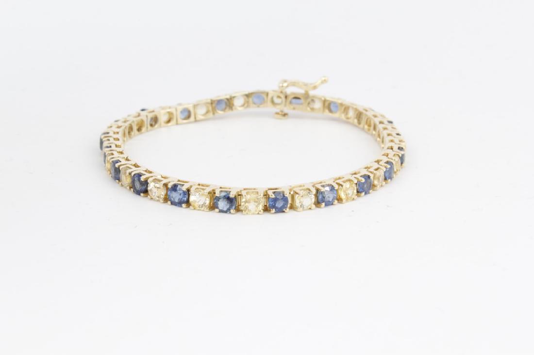 14K YELLOW GOLD BLUE AND WHITE SAPPHIRE TENNIS: 14K YELLOW GOLD BLUE AND WHITE SAPPHIRE TENNIS 14k yellow gold ladies tennis bracelet with blue and white sapphires. marked 14k. Weight: 14.4 g Size: 7"