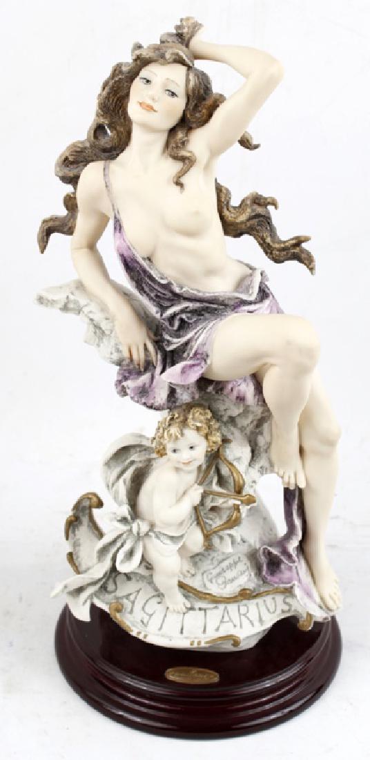 GIUSEPPE ARMANI PORCELAIN "SAGITTARIUS" FIGURINE: GIUSEPPE ARMANI PORCELAIN "SAGITTARIUS" FIGURINE Giuseppe Armani porcelain figurine zodiac "Sagittarius". A woman draped in purple fabric with cupid under her. Number 0698C, in original box. Size: 15.
