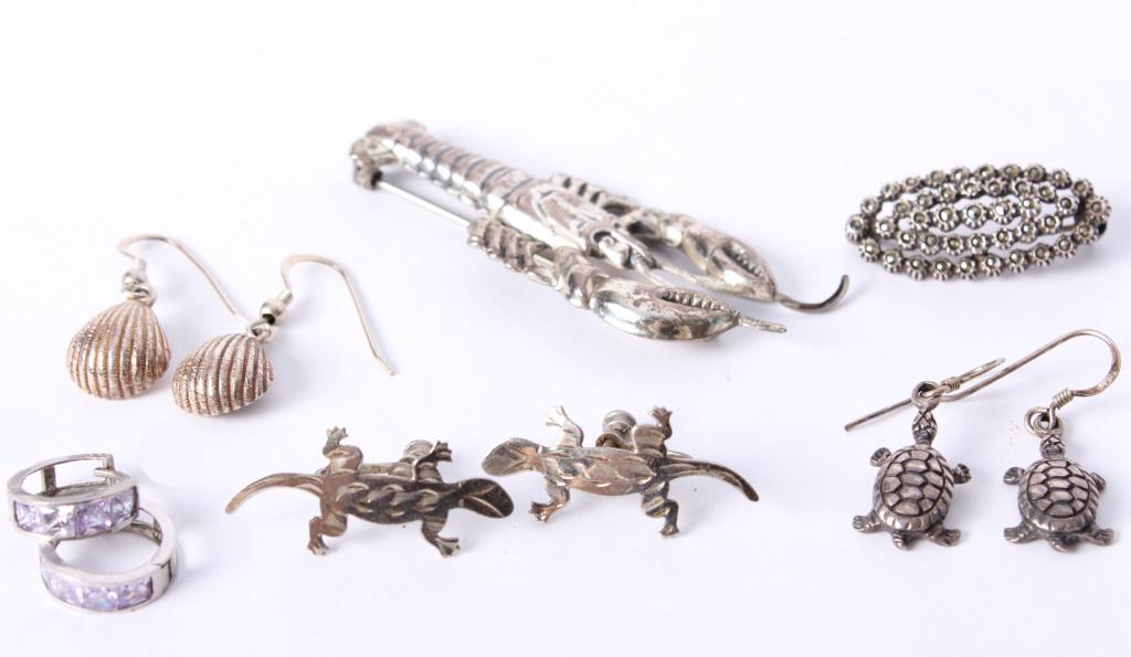 STERLING SILVER LADIES EARRINGS & BROOCHES - 6: STERLING SILVER LADIES EARRINGS & BROOCHES - 6 Sterling silver ladies earrings and brooches - lot of 6. Includes 1 lobster brooch, 1 marcasite brooch, a pair of amethyst hoop earrings, a pair of turtl