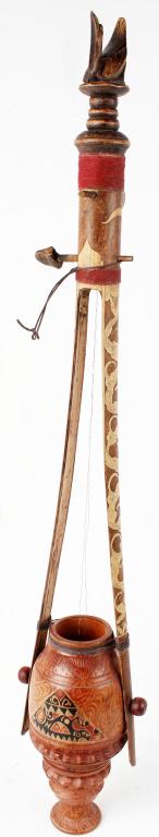 ANTIQUE PRIMITIVE TIBETAN STRINGED INSTRUMENT: ANTIQUE PRIMITIVE TIBETAN STRINGED INSTRUMENT Antique primitive Tibetan stringed instrument. Two strings that tighten by turning the base, ornately decorated with a hand carved bird at the top. Measur