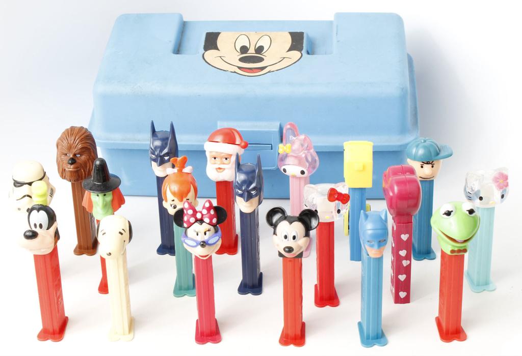 MIXED LOT OF PEZ DISPENSERS - 19 W/ MICKEY BOX: MIXED LOT OF PEZ DISPENSERS - 19 W/ MICKEY BOX Mixed lot of 19 PEZ dispensers, varied styles and ages, accompanied by Mickey Mouse box. Condition: good, box missing handle, some pez with damage.