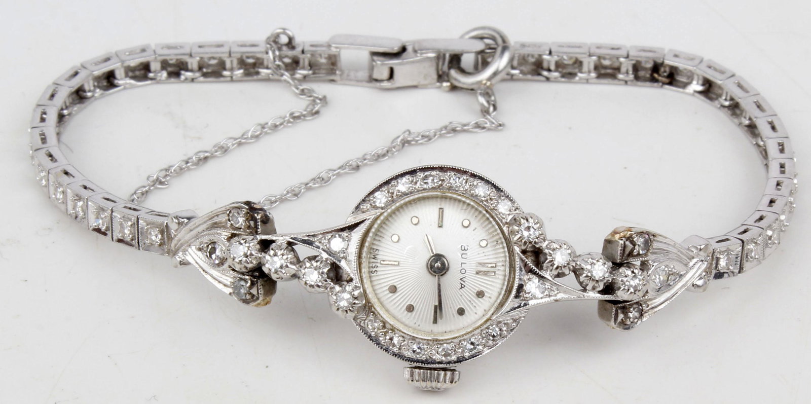 LADIES 14K WHITE GOLD AND DIAMOND BULOVA WATCH: Ladies 14k white gold and diamond Bulova watch. 14mm face with safety chain. Weight: 15.6 g
