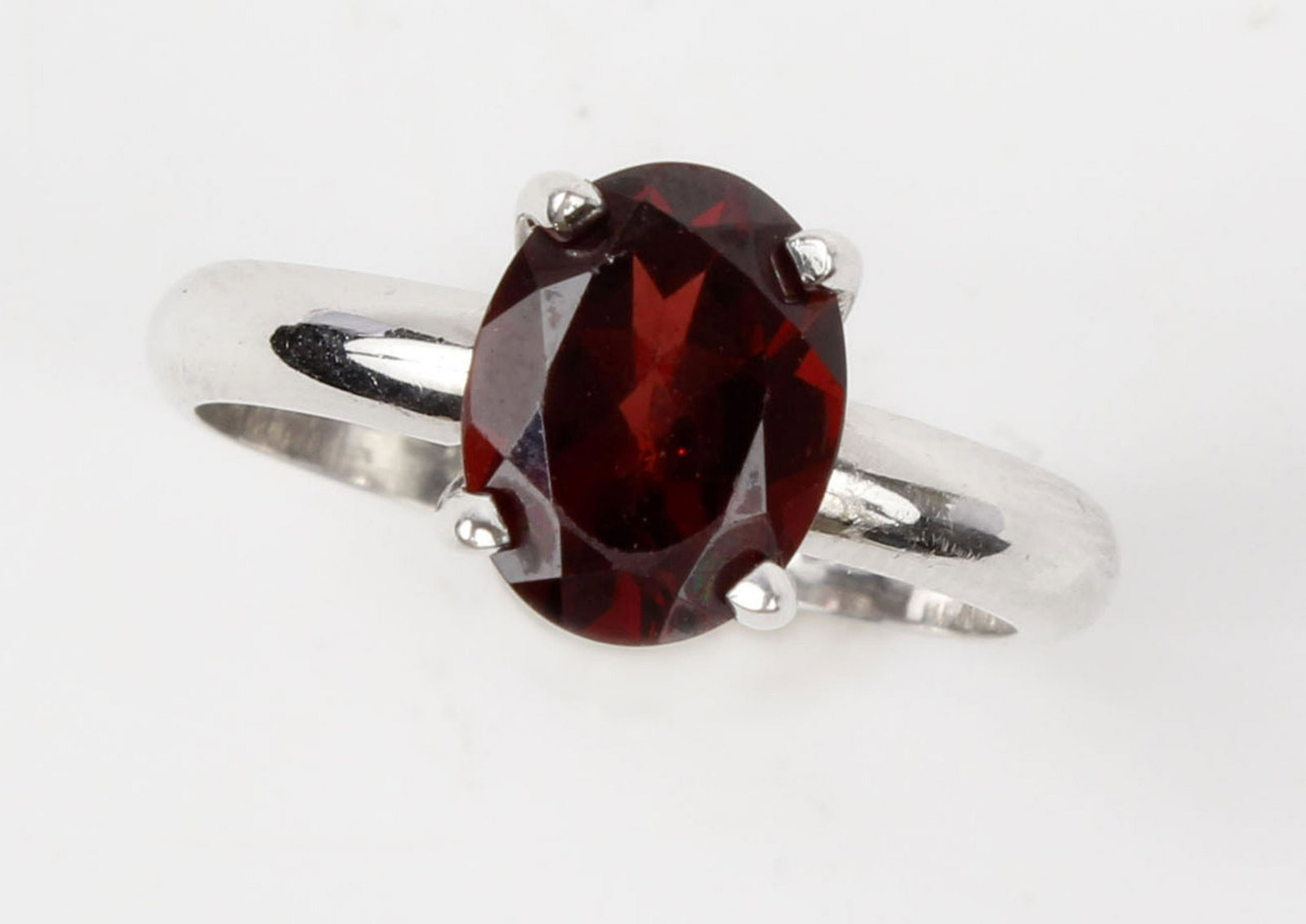14K WHITE GOLD OVAL GARNET SOLITAIRE RING: 14k white gold solitaire oval garnet. 7mm x 9mm oval garnet prong solitaire setting. Weight: 3.4 Size: 6 Condition: very fine