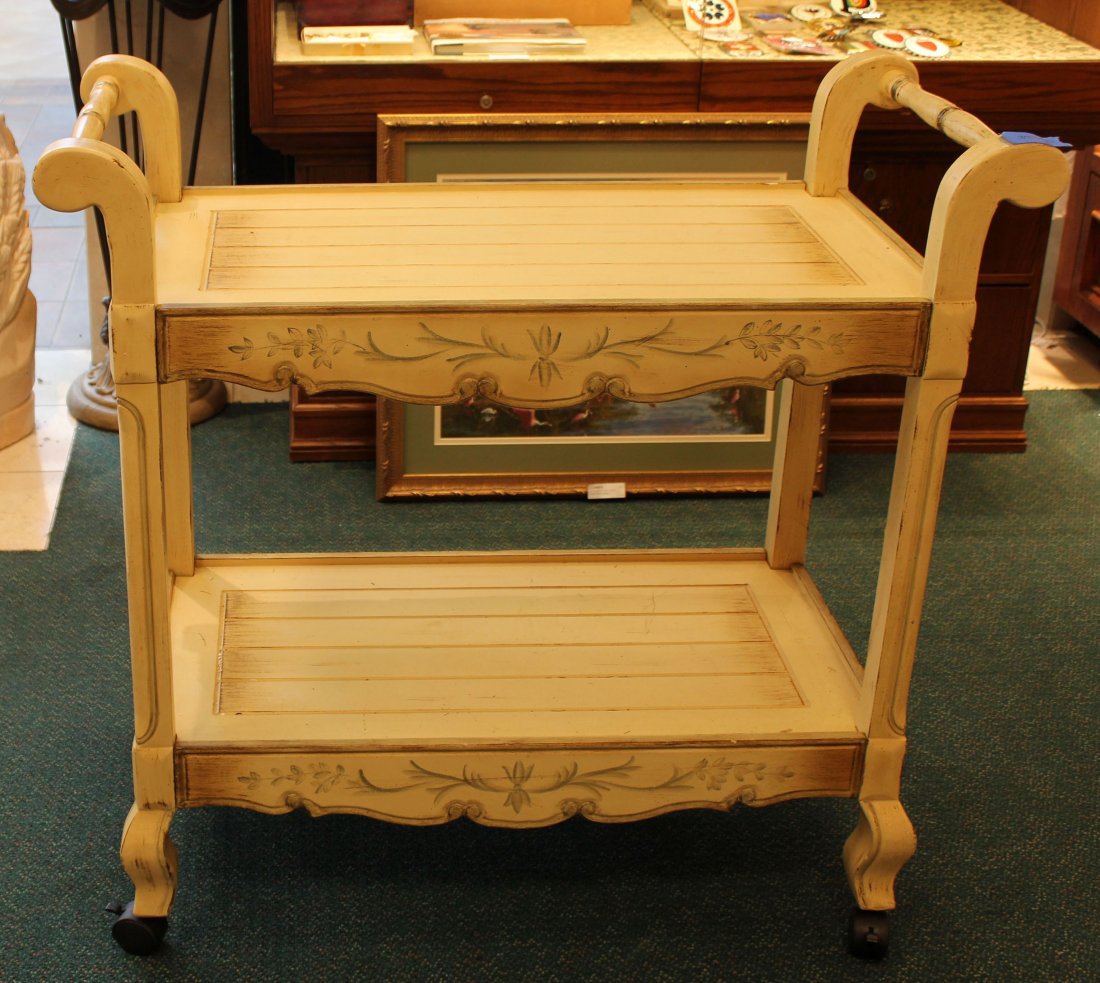 CREAM COLORED ROLLING CART WITH PAINTED DESIGN: Cream colored wooden rolling cart with painted design. 4 locking wheels provide stability when not in use. 39"Wx17.5"Dx37.5"H