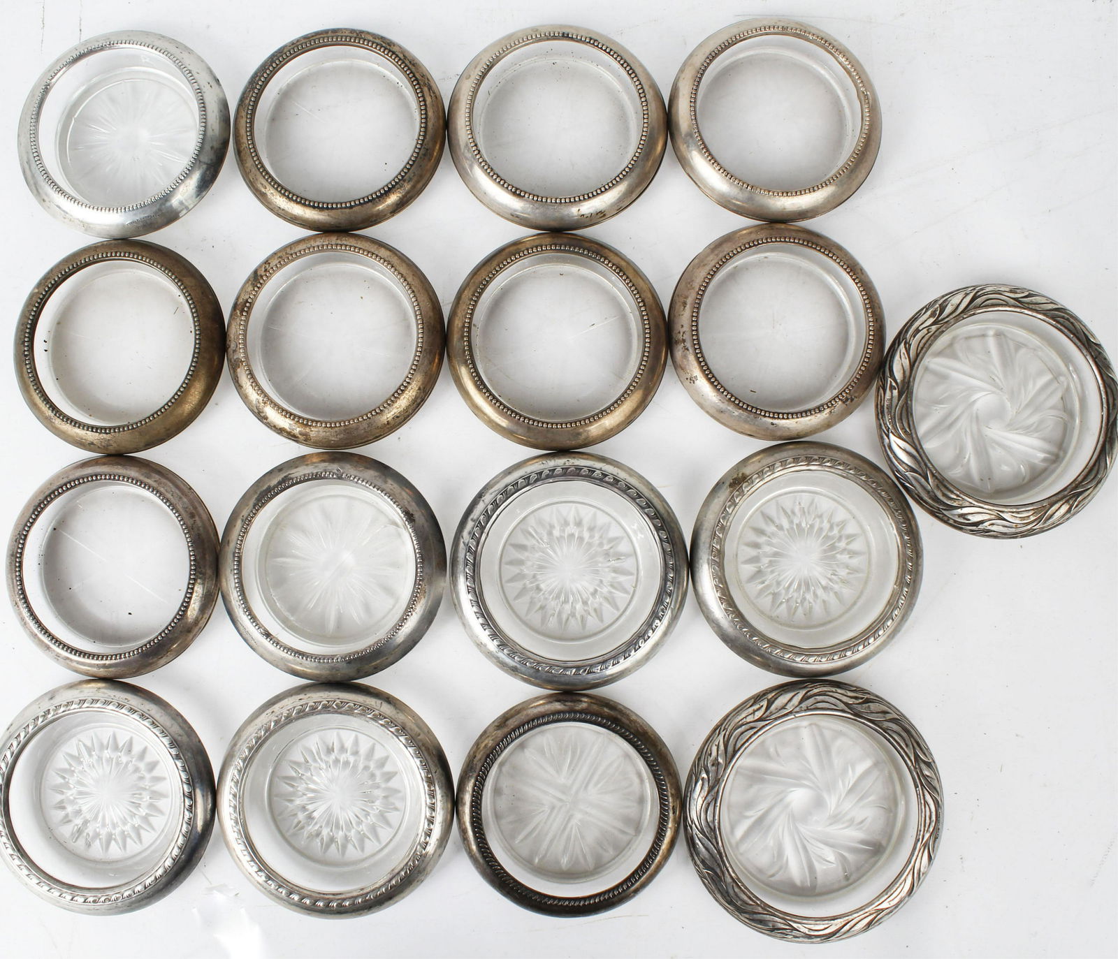 STERLING SILVERR AND CRYSTAL COASTERS: Sixteen Sterling silver and crystal coasters. Traditional 4" diameter design with solid silver rims. Condition: Fair