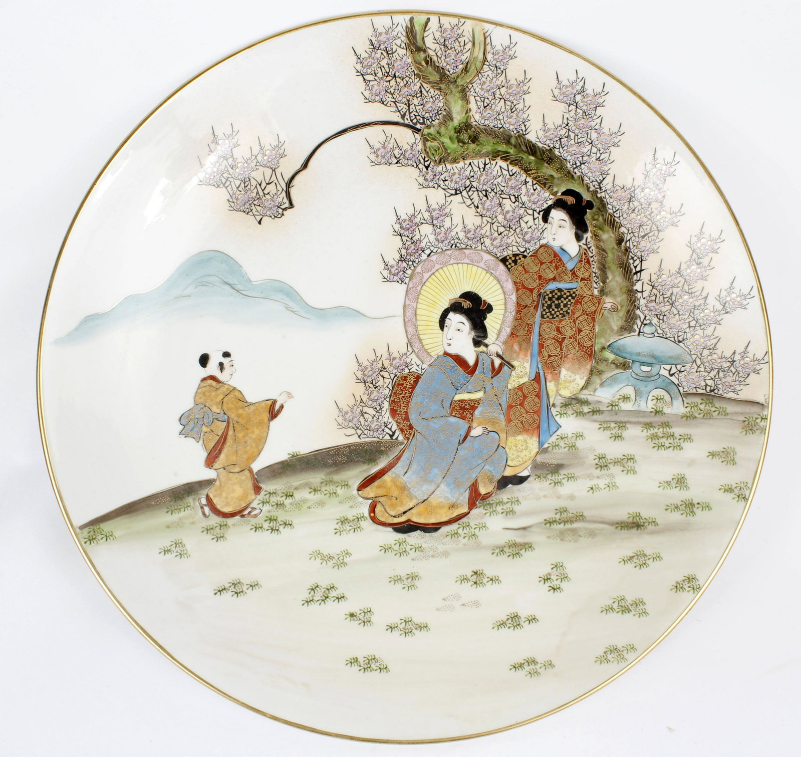EXTRA LARGE CHARGER PLATE GEISHA GILT: Extra large size charger plate Japanese Kutani. Hand painted porcelain. Several geisha out for a walk. Gilt painted throughout. Signed underneath. 18" Diameter Size: 18" Condition: Very Fine