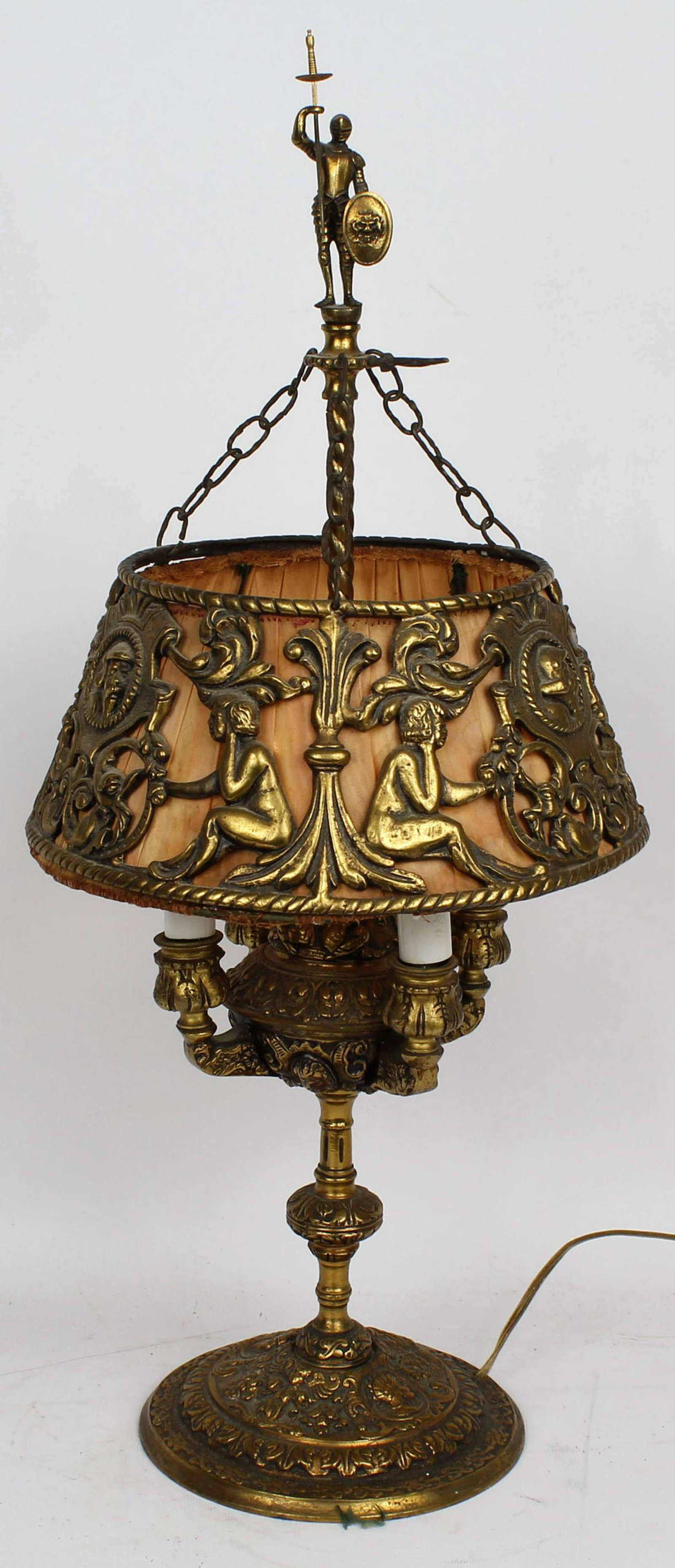 BRASS LAMP SUSPENDED SHADE KNIGHT TOPPER GILT: Antique brass lamp gilt painted with 4 bulbs in simulated candle sleeves. Shade is suspended from chains within a brass cover. Finial is a knight with a sword. Condition: Very Fine
