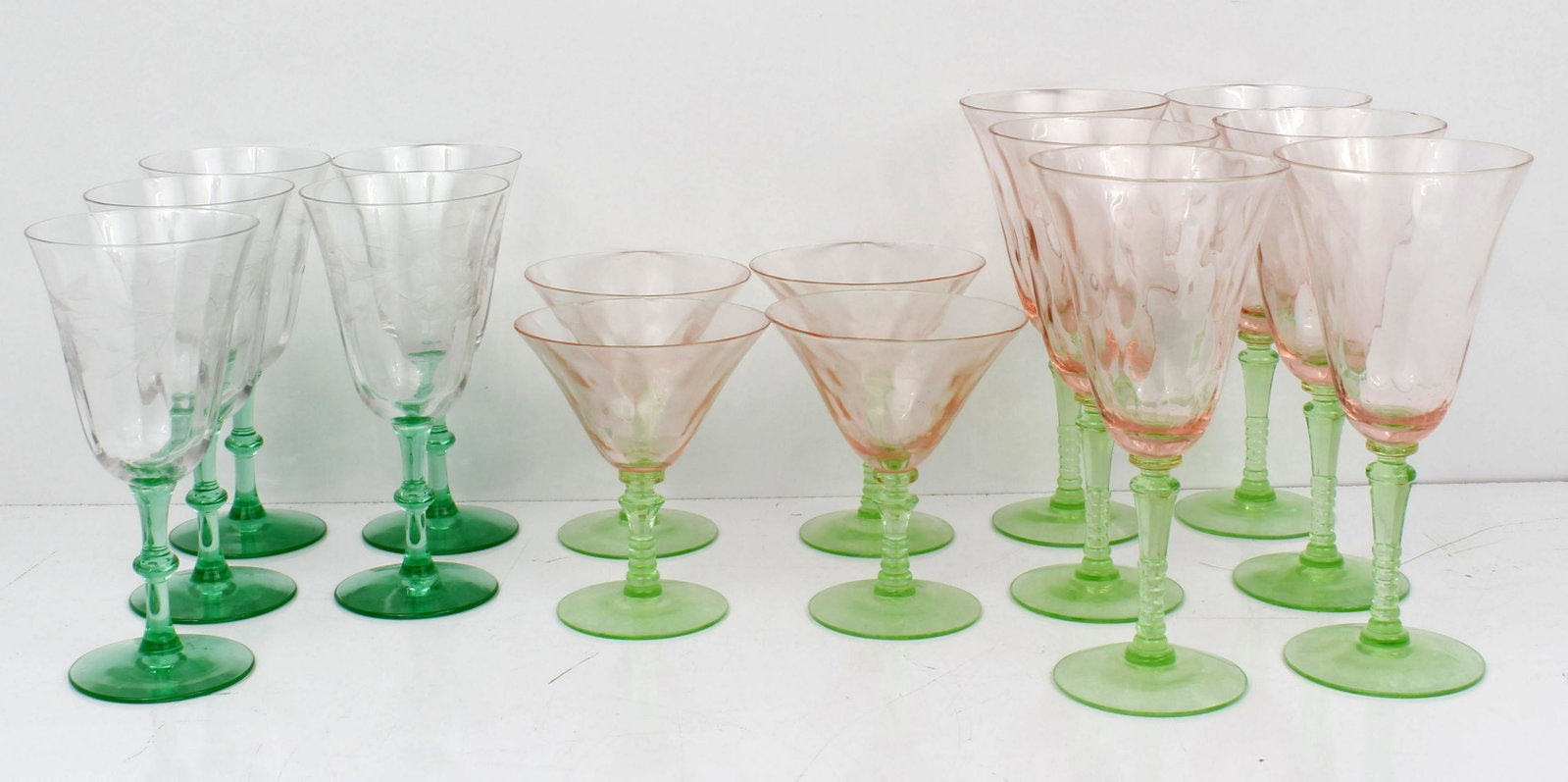 VASELINE GLASS SET OF WINE GLASSES: 115203VASELINE GLASS SET OF WINE GLASSES Uranium oxide enriched Vaseline glass. 4 cocktail's, 5 clear top wine and 5 rose colored flutes. Condition: Fine-Small Chips