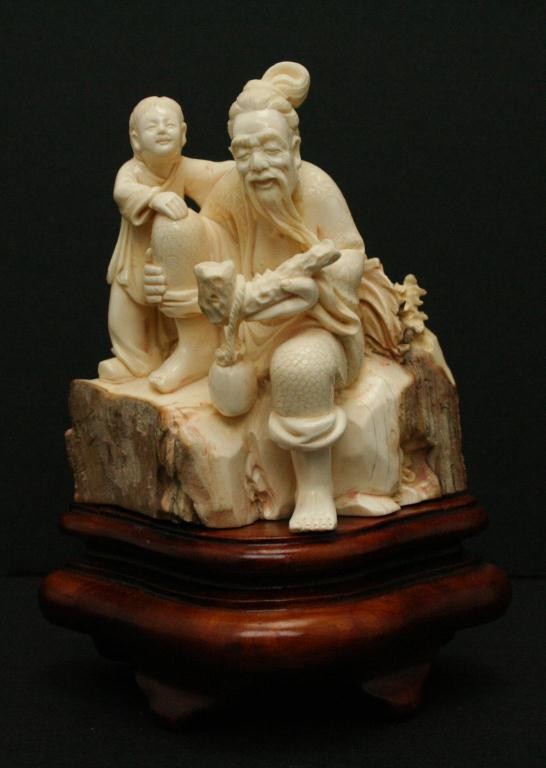 SUPERB JAPANESE IVORY OKIMONO OF AN OLD MAN: SUPERB JAPANESE IVORY OKIMONO OF AN OLD MAN Standing 4.5 inches. Well executed piece showing and old man with a pipe and grandson. UnSigned. On wood stand. Size: see discription Condition: VGC EST. 40