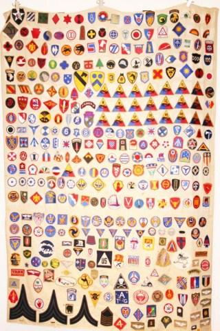 SHEET OF ORIGINAL WWII MILITARY PATCHES: SHEET OF ORIGINAL WWII MILITARY PATCHES WWII veterans war time collection of patches and badges. Jim Glenn collected while working in supply in the 155 Infantry. A German prisoner of war sewed the pat