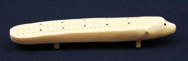 WALRUS TUSK IVORY POLAR BEAR CRIBBAGE BOARD: WALRUS TUSK IVORY POLAR BEAR CRIBBAGE BOARD A carved cribbage board, signed by the artist "Gordon Dozevadrmk". Size: 6.75" Condition: VGC EST. $100-200