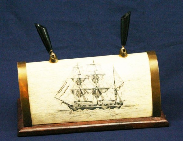 WALRUS TUSK IVORY SCRIMSHAW DESK PEN STAND: WALRUS TUSK IVORY SCRIMSHAW DESK PEN STAND Made from a large tusk and with a three mast ship scrimshaw signed K Neurman. One of the pen holders has damage. Mounted to a wood and brass stand. Size: 8.5