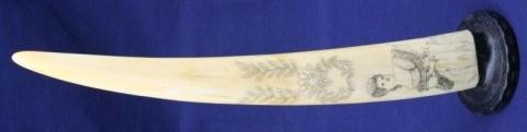 WALRUS IVORY TUSK SCRIMSHAW OF A LADY: WALRUS IVORY TUSK SCRIMSHAW OF A LADY Naive portrait of a young lady. The tusk is mounted to a jar top. Size: 13" Condition: GC EST. $100-200