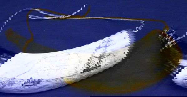 A FINE SCRIMSHAW POWDER HORN: A FINE SCRIMSHAW POWDER HORN A well executed scrimshaw powder horn with wood bung and top. The scrimshaw depicts a sailor being rowed ashore in a jolly boat, a poem is written above "Home is the sailo