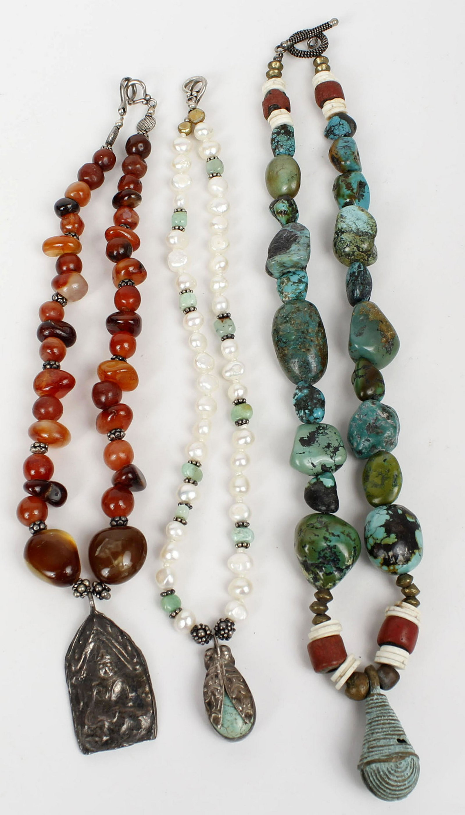 3 PRIMITIVE DESIGNER NECKLACES - TURQUOISE: 3 primitive designer necklaces with silver tone clasps and gemstones. Turquoise, carnelian, etc. Condition: Very Fine
