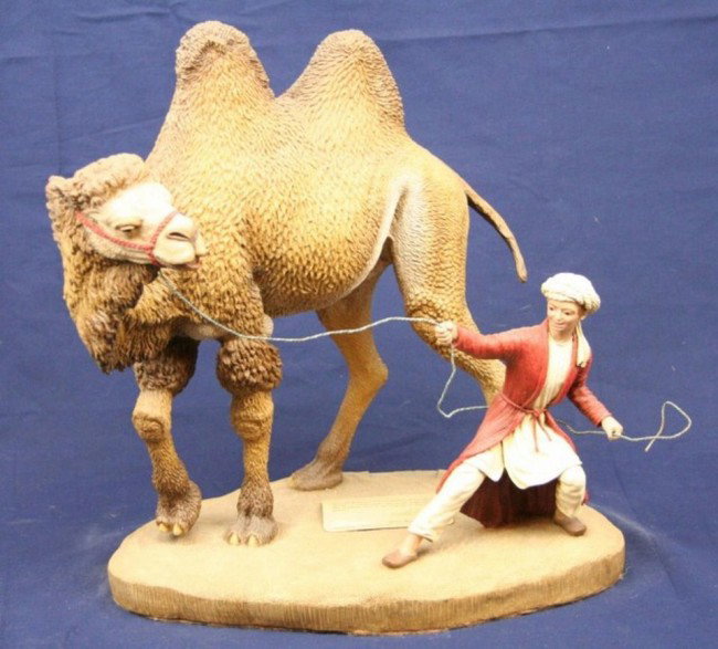 CREART CAMEL STATUE: CREART CAMEL STATUE Creart handcrafted marble dust sculpture of a Camel and boy. Numbered 424 of 2500. Boy has been repaired. Size: 15" Condition: VGC Est. 150-300