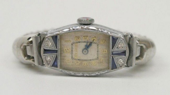 LADIES ART DECO SAPPHIRE & DIAMOND BULOVA WATCH: LADIES ART DECO SAPPHIRE & DIAMOND BULOVA WATCH Bulova 15 jewel movement in 14K white gold case with sapphires and diamonds. Speidel stainless steel retractable band. Working, but no warranted. Condit