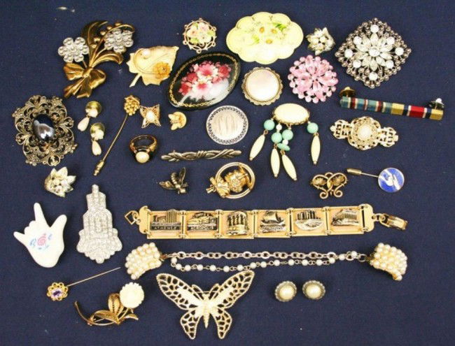 SMALL LOT OF BETTER QUALITY COSTUME JEWELRY: SMALL LOT OF BETTER QUALITY COSTUME JEWELRY A good mixed lot of costume jewelry including two named pieces. "Sarah Cov" butterfly and "Trifari" Grape pin. Rhinestone brooches and more. Weight: About 3