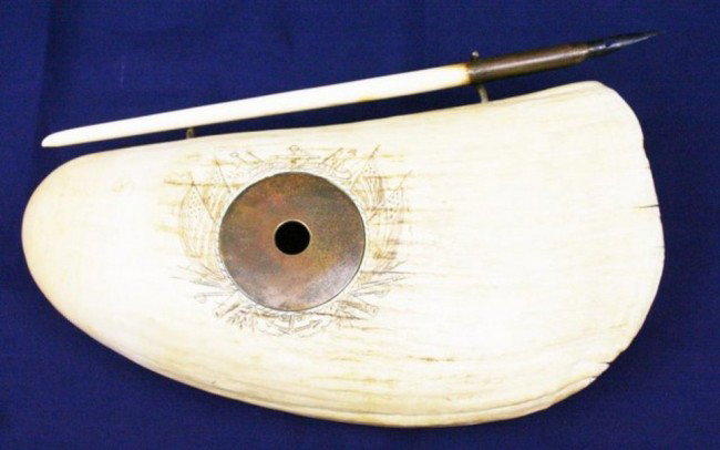 PRESENTATION TOOTH SCRIMSHAW INKWELL Capt LAWRE: A rare and possibly unique piece. A whales tooth scrimshaw inkwell and pen holder with anchor and flags with scroll "Lake Erie". The underside is engraved "Presented to Captain H Lawrence by the Offic