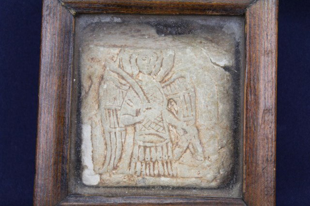 MEDIEVAL CHURCH SAND STONE CARVED TILE FRAGMENT: MEDIEVAL CHURCH SAND STONE CARVED TILE FRAGMENT Sandstone fragment with a carving of an angel wearing armor and carrying a sword. Size: 2.5 x 2.5 inches Condition: As found Est.$100-300