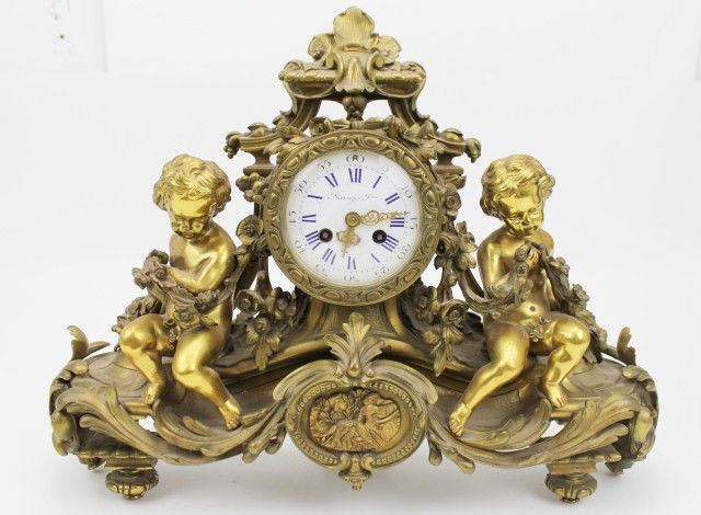 NAPOLEON III ORMOLU MANTLE CLOCK BY RAINGO FRERES: NAPOLEON III ORMOLU MANTLE CLOCK BY RAINGO FRERES Raingo Freres, Paris, circa 1870. White porcelain enamel dial with blue/black Roman numerals, with bell-strike movement, complete with pendulum and ke