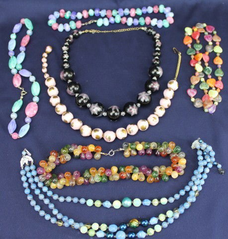 COSTUME JEWELRY LOT OF MULTICOLORED BEAD NECKLACES: Lot of seven costume beaded necklaces. Lot Includes: two large bead necklaces with designs, multicolored heart necklace, three pastel colored necklaces, and a multicolored teardrop bundle necklace. We
