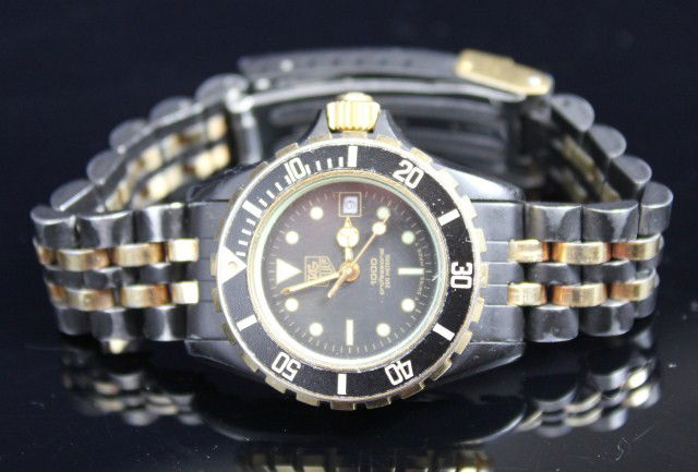 LADIES TAG HEUER 1000 PROFESSIONAL 200M WATCH: Black bodied watch with gilt accents. Black dial of 18mm. Working. Size: 18mm Condition: VGC