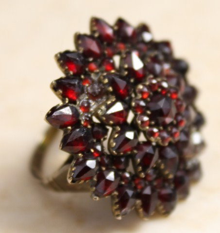 LADIES STERLING SILVER RING W/ RUBY COLORED STONES: Ladies sterling silver ring with ruby colored stones forming the shape of a flower. Size 7.5. Weight: 7.7 g Size: 7.5 Condition: VGC