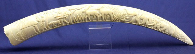 AFRICAN ELEPHANT FULL TUSK CARVING OF A VILLAGE: AFRICAN ELEPHANT FULL TUSK CARVING OF A VILLAGE Adult elephant ivory tusk carving of an African village scene. Almost 3 feet long. Size: 35.5" Condition: VGC Lot: 15366