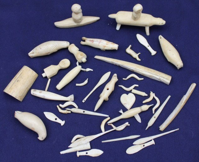 ALASKAN WALRUS TUSK IVORY & BONE ANIMALS & TOYS: ALASKAN WALRUS TUSK IVORY & BONE ANIMALS & TOYS A good varied lot of carved bone and ivory animals including seals, walrus, bear and whale. Other toys include a canoe, fish, paddles and more. Size: va
