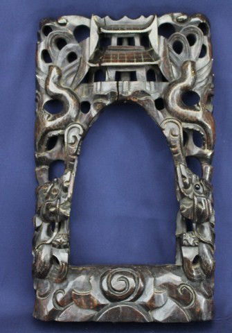 CHINESE HARD WOOD FRAME W/ SILVER INLAID WIRE: CHINESE HARD WOOD FRAME W/ SILVER INLAID WIRE A well carved hardwood frame with silver wire inlay. The piece is carved with dragons, each of which has black jade eyes (one absent). Some old age splitt