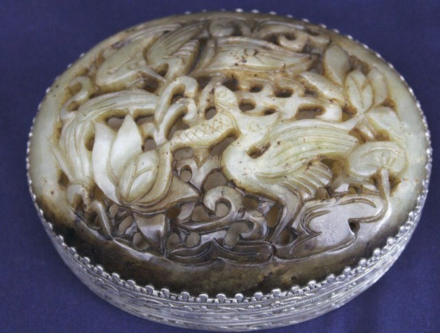 CHINESE GREEN JADE SILVERED & MIRRORED BOX: CHINESE GREEN JADE SILVERED & MIRRORED BOX Silvered metal container with carved celadon green jade top. The inner top has a mirror. The jade is carved in the form of birds of paradise. Size: 4 x 4.75 