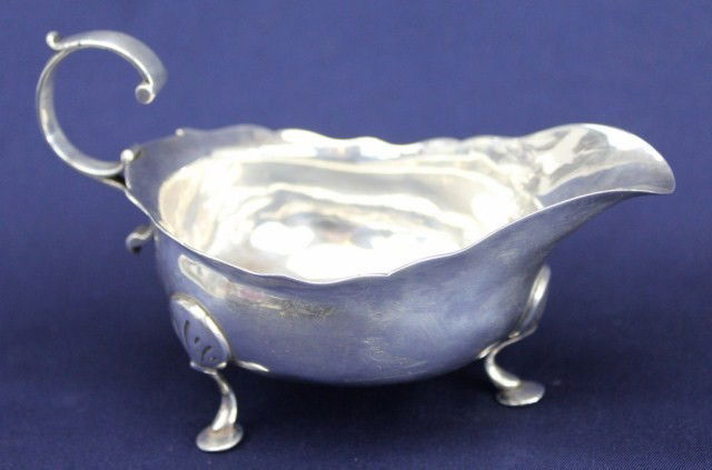 A FINE GEORGIAN STERLING SILVER GRAVY BOAT 1774: A FINE GEORGIAN STERLING SILVER GRAVY BOAT 1774 A sterling silver gravy boat showing clear hallmarks for Newcastle 1774-75 and the makers mark for James Crawford, Active from 1761 until his death in 1