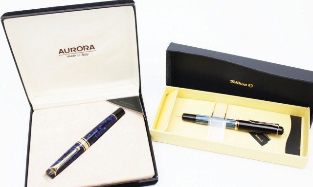 AURORA 996 & PELIKAN M200 FOUNTAIN PENS: AURORA 996 & PELIKAN M200 FOUNTAIN PENS Aurora 996 piston fountain pen colored in a shimmering blue. Nib is marked 14K yellow gold and "F". Pelikan M200 piston fountain pen with a blue colored pearl-l