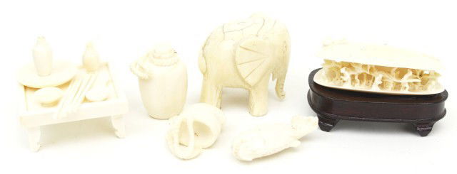 MIXED LOT IVORY FIGURES: MIXED LOT IVORY FIGURES A Chinese ivory carving of a village in a clam shell on a wooden stand. 2.75" long. A 2" carved elephant, from a larger item. An ivory table with place setting. A fish, a jug,