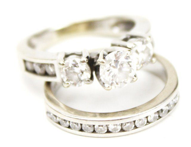 LADIES 14K GOLD AND DIAMOND WEDDING SET: LADIES 14K GOLD AND DIAMOND WEDDING SET Beautiful 14K white gold engagement ring with 3 stone design. Center diamond is approximately a 0.6 ct round brilliant cut of I-1 clarity and E color. Accompani